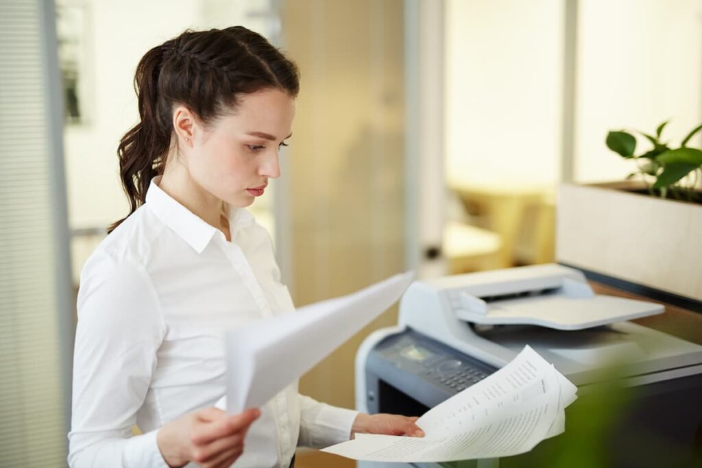 Copier Lease Agreement. Woman looking at copy machine leasing agreement