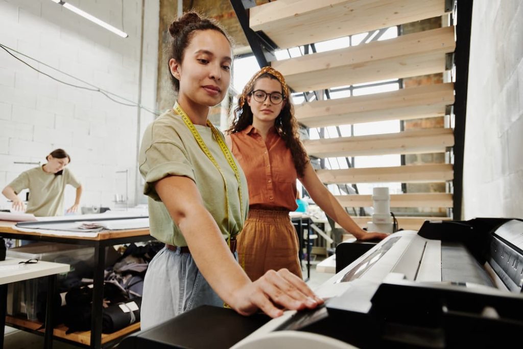 Two women choosing copier machine