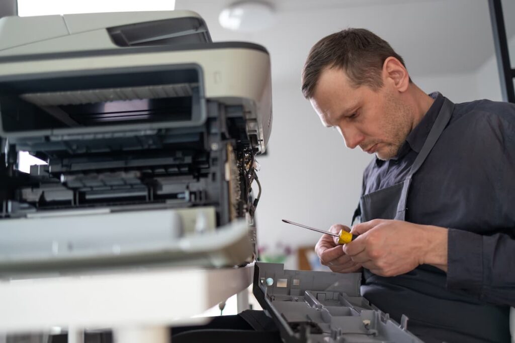 A man is repairing a printer