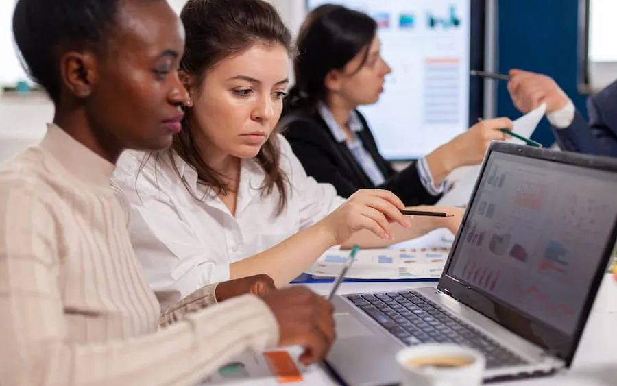 A team talking through their systems at a laptop