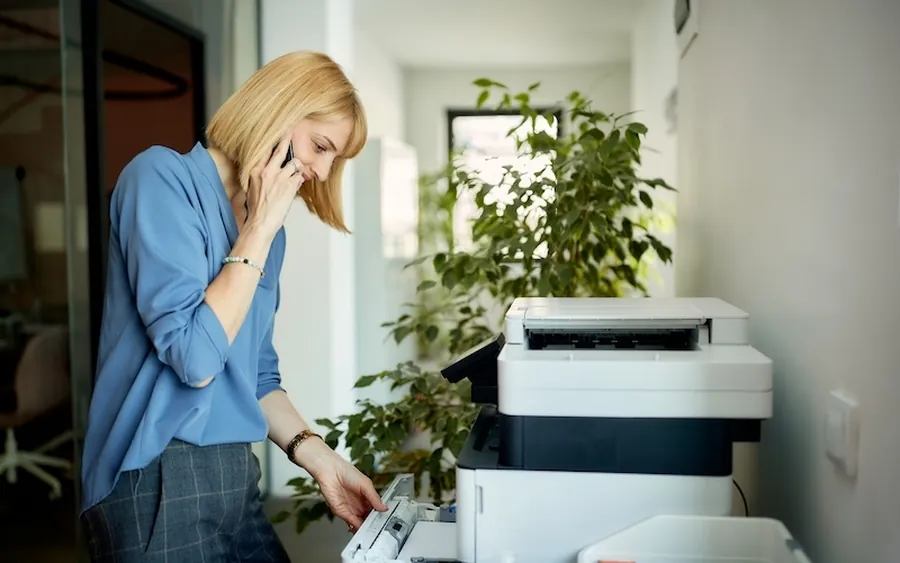 An office manager on the phone at the copier