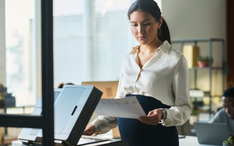 Woman scanning document on a copier for managed print service